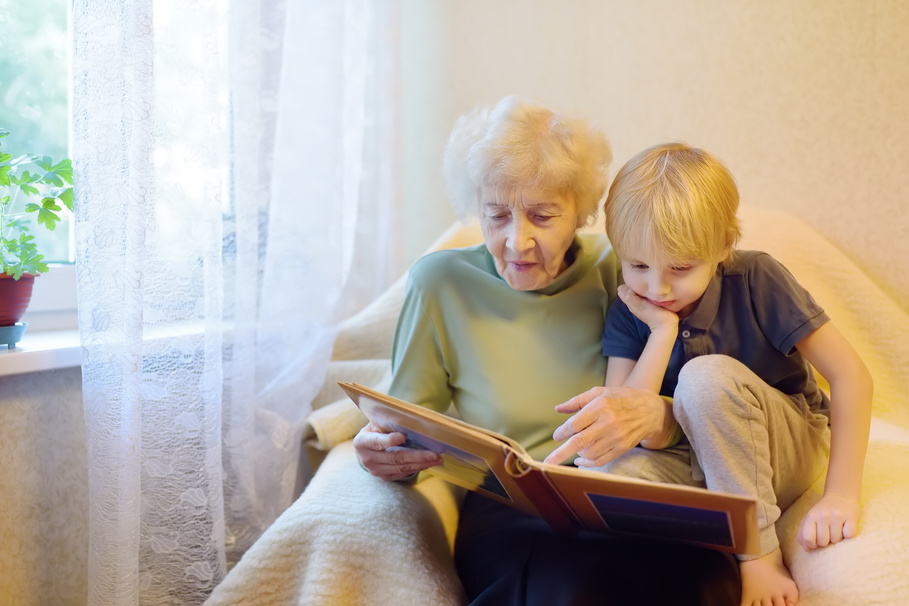 Grandmother Showing Album to Grandson on the Bed